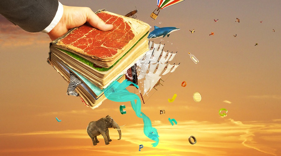 Concept of reading. Man's hand holding magic book with falling letters animals and other objects from this book. Concept of dreaming.