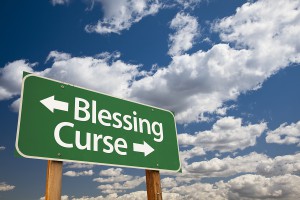 Blessing, Curse Green Road Sign Over Dramatic Blue Sky and Cloud