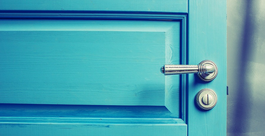 open wooden door painted in blue with a beautiful a metal handle and the castle